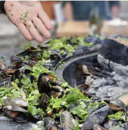 Mejillones cocinados al brasero COEO sobre plancha con chalotas y perejil fresco, al fuego de leña.