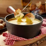 Fondue saboyana preparada en brasero COEO con quesos fundidos y trozos de pan
